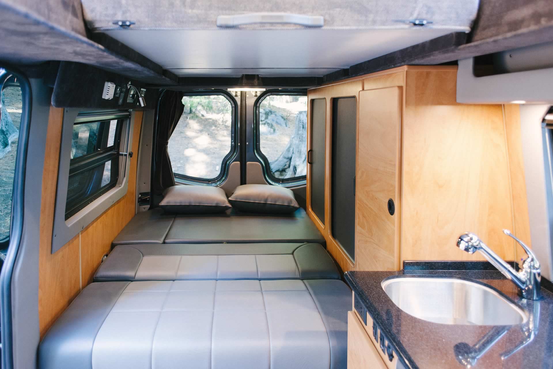 Interior view of Sportsmobile camper van conversion with sofas turned into beds.