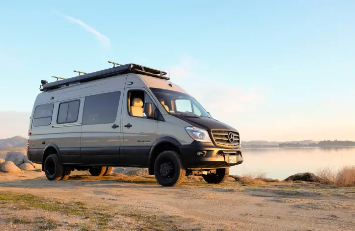 Mercedes Sprinter van parked next to a lake.