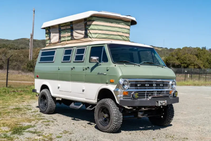 Green and white classic ford van with penthouse roof.